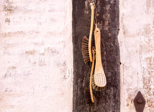 Vecchi pennelli retrò pendono decorativamente su parete di legno — Foto Stock