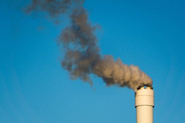 uzun boylu baca üzerinden açık mavi gökyüzü karşı kirli duman