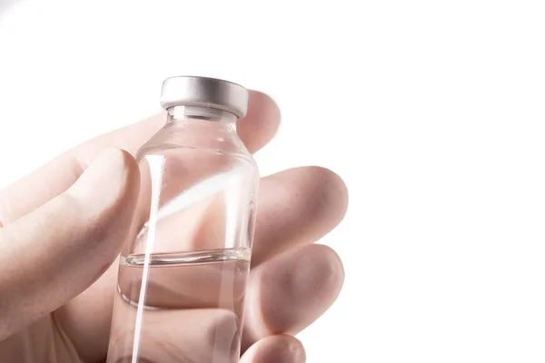 Hand with protective glove holding the vial — Stock Photo, Image