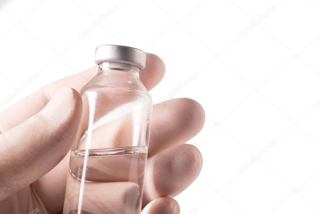 Hand with protective glove holding the vial