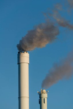 uzun boylu baca üzerinden açık mavi gökyüzü karşı kirli duman