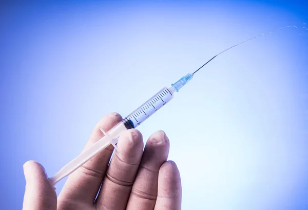 Hand with glove holding the syringe — Stock Photo, Image