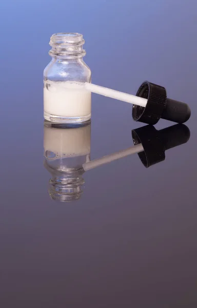 Dropper bottle with milk white liquid — Stock Photo, Image