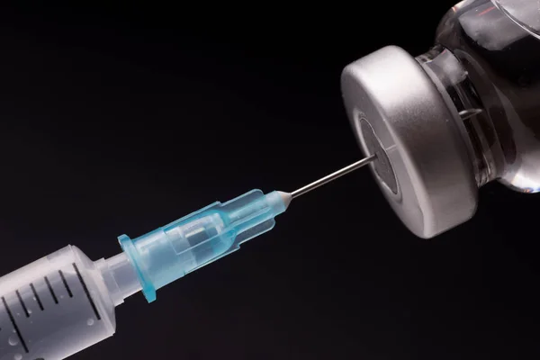 Seringa médica com a agulha no frasco para injetáveis — Fotografia de Stock