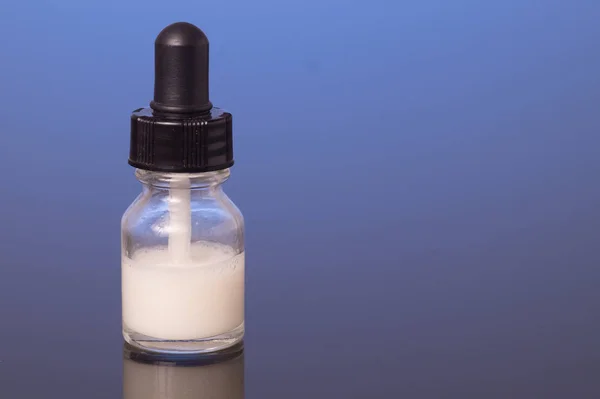 Dropper bottle with milk white liquid — Stock Photo, Image