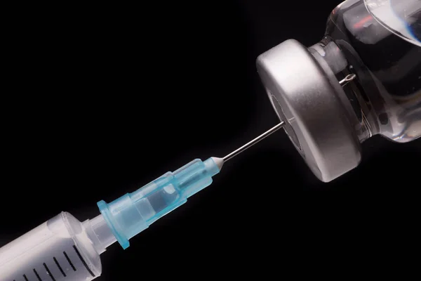 Medical syringe with the needle in the vial Stock Image