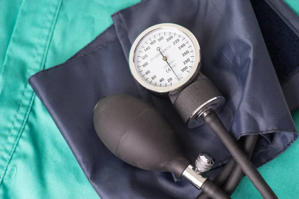 Dispositivo di pressione sanguigna situato sullo sfondo verde dell'ospedale . — Foto Stock