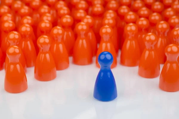 Peões de jogo laranja conceituais e um peão de jogo azul — Fotografia de Stock