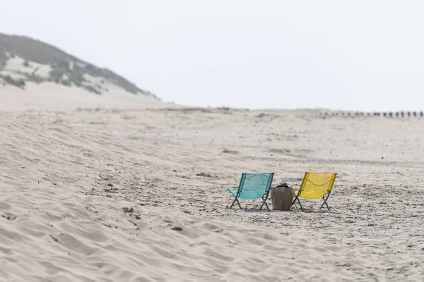 Mavi ve sarı bir kumsalda katlanır sandalye — Stok fotoğraf