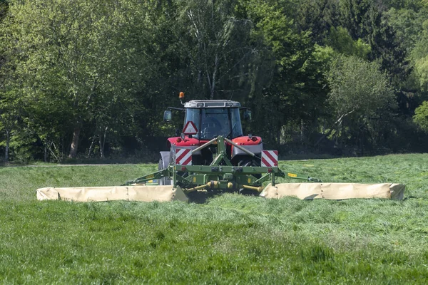 Červený Traktor Sekání Vysoké Zelené Trávy Začátku Jara Nizozemsku — Stock fotografie