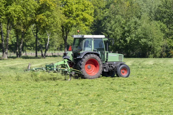 Zelený Traktor Sekání Vysoké Zelené Trávy Začátku Jara Nizozemsku — Stock fotografie