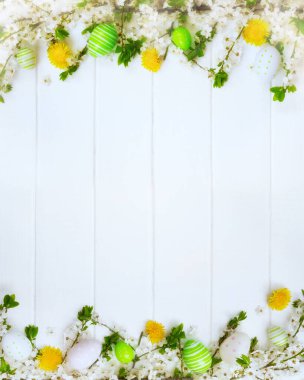 Paskalya süslemeleri, bahar çiçekleri ve beyaz tahtalarda yumurtalar..