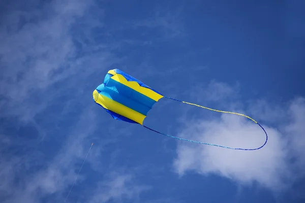 Aquilone, giallo e blu nel vento contro il cielo con le nuvole — Foto Stock