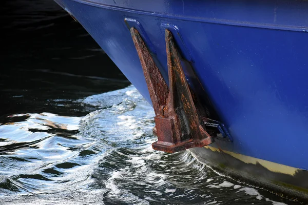 Rostiger Anker auf blauem Rumpf über dunkel reflektierendem Meerwasser, Schiffsdetails — Stockfoto