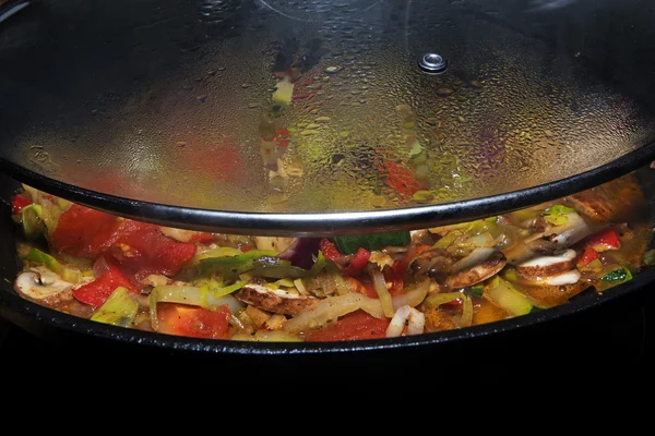Δείτε κάτω από το μισό-ανοίγω γυάλινο καπάκι σε μια κατσαρόλα με βραστό λαχανικών — Φωτογραφία Αρχείου