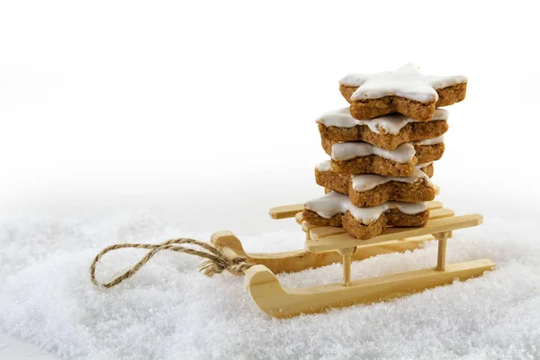 Christmas cookies, cinnamon stars on a wooden sled in the snow — Stock Photo, Image