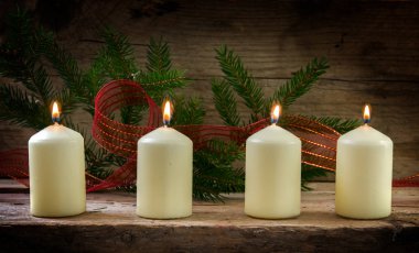 Dört dördüncü advent Noel dekorasyonu bir rustik ahşap tahta üzerinde yanan mum beyaz