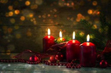 Dördüncü advent, Noel dekorasyon, ahşap arka plan bokeh ışıkları ve kopya alanı ile dört kırmızı yanan mumlar