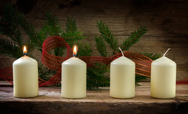 Quattro candele bianche, due delle quali accese al secondo avvento, decorazioni natalizie su una tavola di legno rustica — Foto Stock