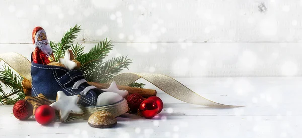 Kinderschuh gefüllt mit Süßigkeiten, Plätzchen und Weihnachtsdekoration für den Nikolaustag am 6. Dezember — Stockfoto