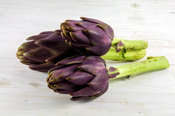 Purple artichokes from italy on white rustic wood — Stock Photo, Image