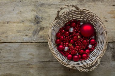 Kırmızı Noel topları ve baubles yukarıdan rustik ahşap, en iyi görünümü üzerinde bir sepet içinde