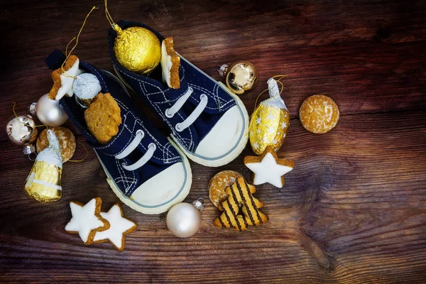 Kinderschuhe gefüllt mit Plätzchen und Weihnachtsdekoration für den Nikolaustag am 6. Dezember — Stockfoto