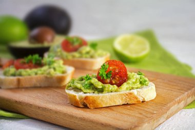 Avokado krem veya guacamole ve domates rustik Ahşap mutfak tahtası ile kanepe sandviç