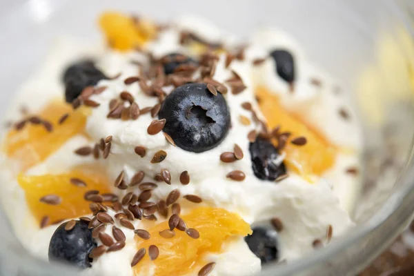Quark, yogurt o ricotta, con mirtilli freschi, arance e semi di lino — Foto Stock
