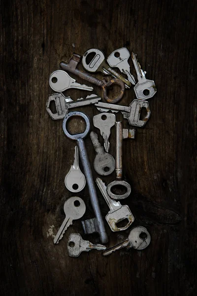 Various old keys in the form of a keyhole on a dark rustic woode — Stock Photo, Image