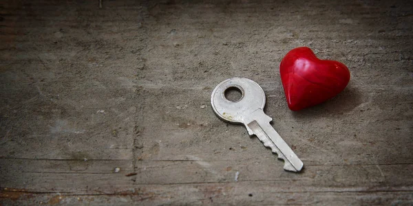 Маленькая красная форма сердца и серебряный ключ на ржавом дереве, концепция f — стоковое фото