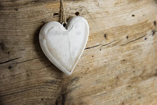 Λευκή καρδιά σχήμα κατασκευασμένο από ξύλο που κρέμεται από ένα w ρουστίκ ξύλινα τοίχων — Φωτογραφία Αρχείου