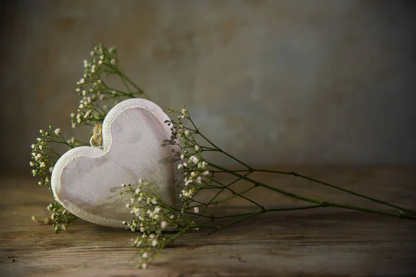 Hjärtat från trä och vita blommor mot en rustik vintage bakgrund — Stockfoto