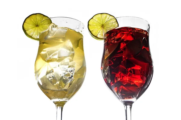 Deux verres à cocktail, mélange de boissons jaunes et rouges avec citron vert et glace isolé sur blanc — Photo