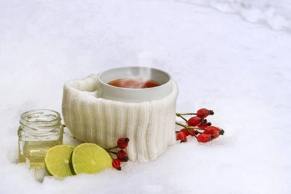 Hot tea from red rose hips with lemon and honey in the snow, winter drink against flu and common cold — Stock Photo, Image