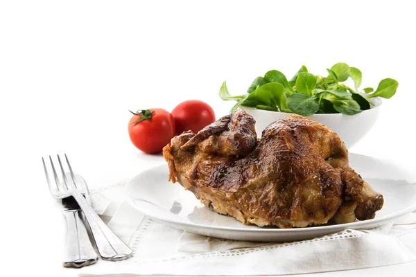 Medio pollo, crujiente a la parrilla, con cubiertos, ensalada y tomates, fondo blanco con espacio para copiar —  Fotos de Stock