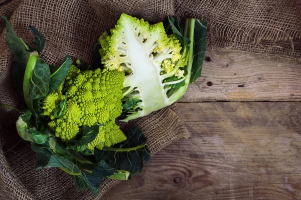 Roman caulifloweror Romanesco broccoli , whole and half on a rustic wood, top view from above with copy space — Stock Photo, Image