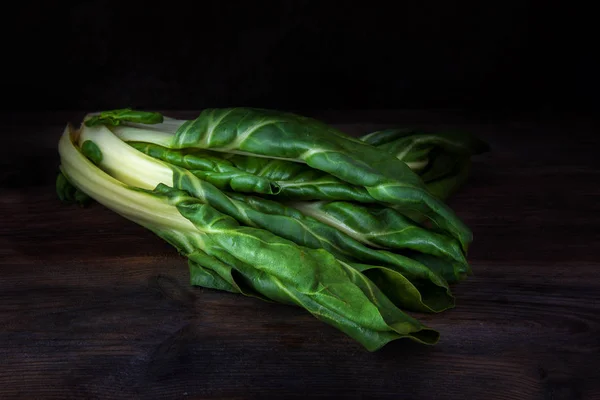 Chard or mangold, raw organic leaf vegetable against a dark wooden background — Stock Photo, Image