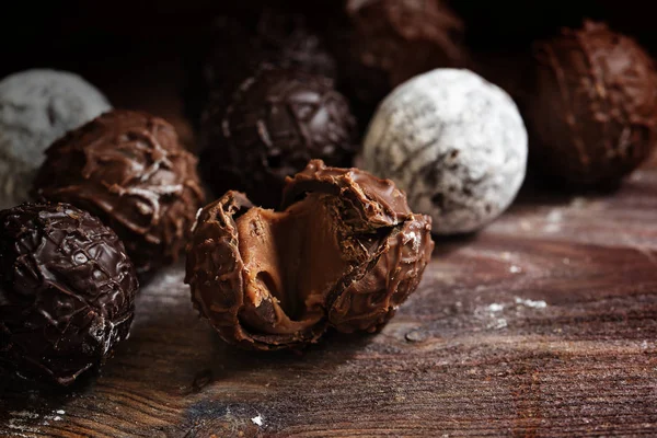 Chocolate, surtido de pralinés redondos de trufa sobre madera rústica oscura —  Fotos de Stock