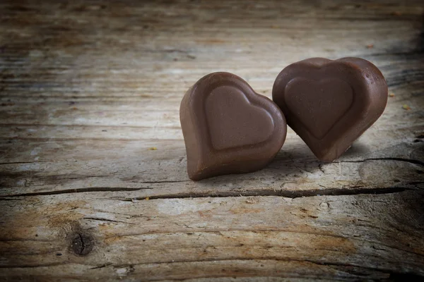 Dos corazones de chocolate, pralinés en tablas rústicas de madera, amor cncept —  Fotos de Stock