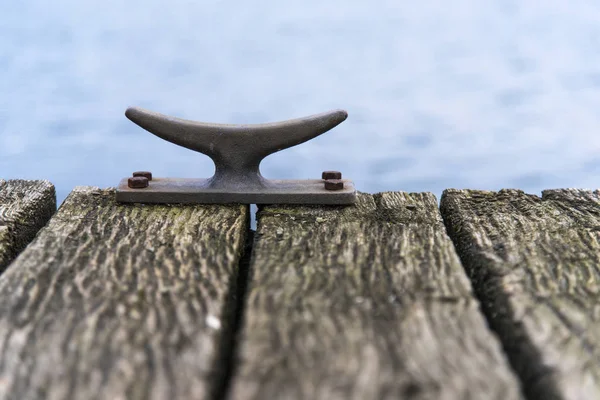 Dissuasore d'ormeggio di metallo su un ponte di legno sul mare, copiare lo spazio — Foto Stock