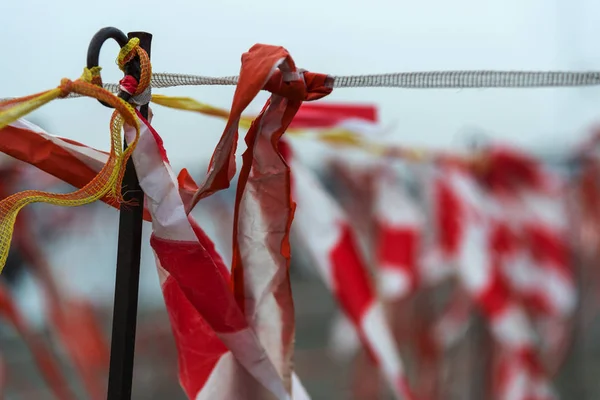 Akadályt szalagot műanyagból, piros-fehér csíkokkal, csapkodott a szélben — Stock Fotó