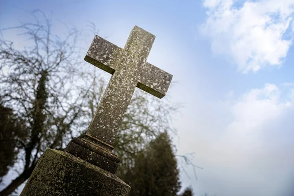 Verweerde stenen kruis of grafsteen tegen de blauwe hemel, memorial day-concept voor oorlog dode of religieuze christelijke symbool voor vakantie zoals goede vrijdag, Pasen en halloween — Stockfoto