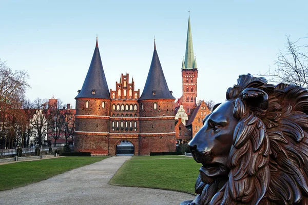 Lion de bronze devant le Holstentor à Luebeck, porte médiévale de la ville — Photo