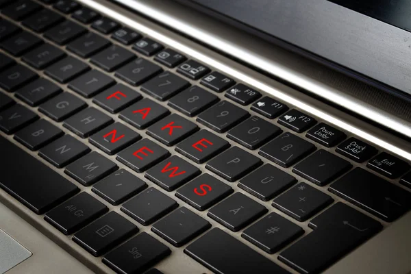 Ordenador portátil teclado con las palabras FAKE NEWS en letras rojas en teclas negras — Foto de Stock