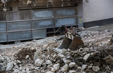 Bir yıkılmış bina, şehir içi inşaat sitedeki çöp Ekskavatör kürek yatıyor