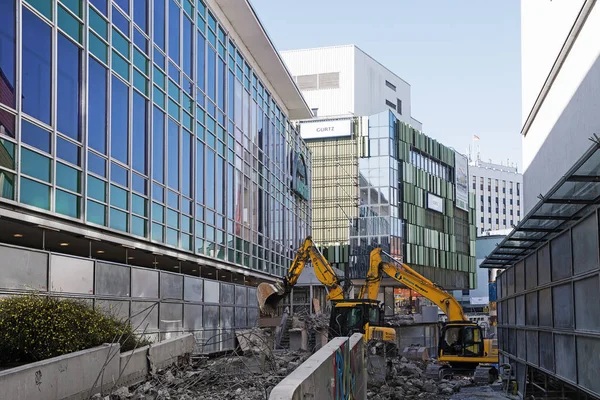 PADERBORN, ALEMANIA, 13 DE MARZO DE 2017: Sitio de construcción, dos excavadoras entre grandes almacenes espejados — Foto de Stock