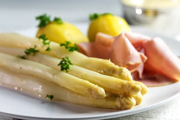 Świeże szparagi biały danie z ziemniaków i szynką, lekkie podłoże, szczegół — Zdjęcie stockowe