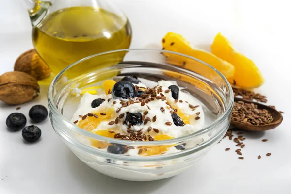 Colazione sana con quark o ricotta e olio di fodera, mirtilli freschi, semi di arancia, noce e lino, fondo grigio chiaro — Foto Stock