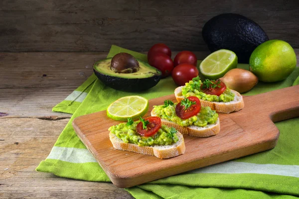 Crema de aguacate o guacamole en sándwiches de baguette con ingredientes, canapés para fiesta o buffet — Foto de Stock